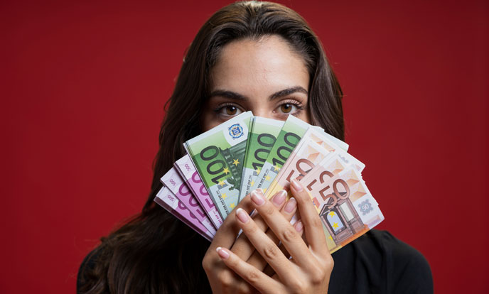 vrouw die haar gezicht bedekt met geld